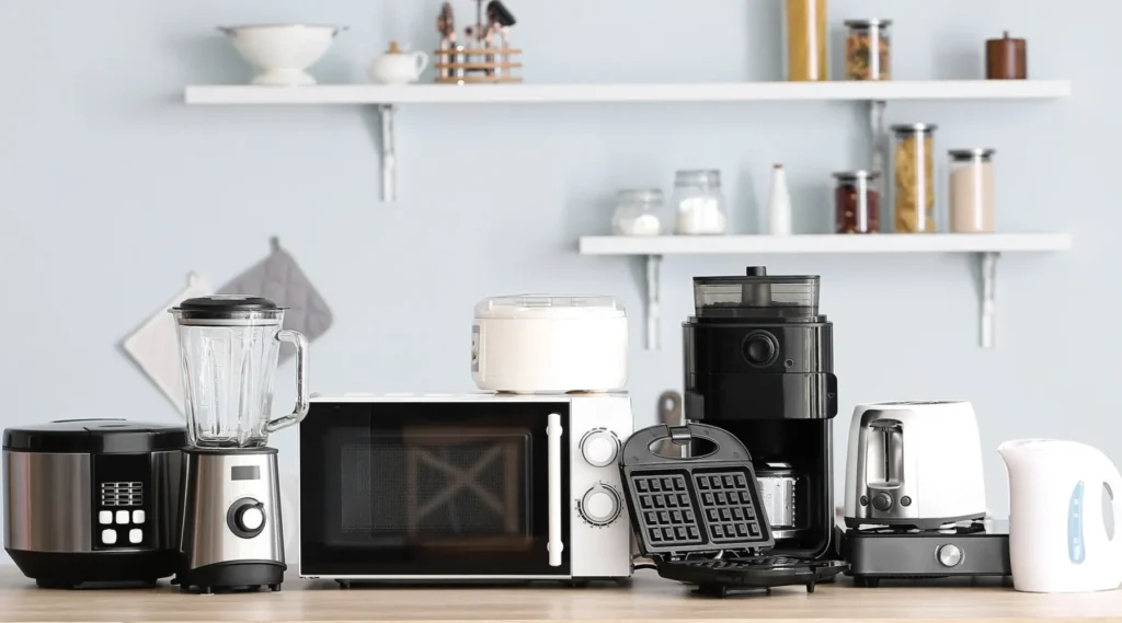 Assorted kitchen appliances including a blender, microwave, coffee maker, waffle maker, kettle, and rice cooker, displayed on a countertop, representing essential tools for home cooking and appliance repair services in Northern Virginia.